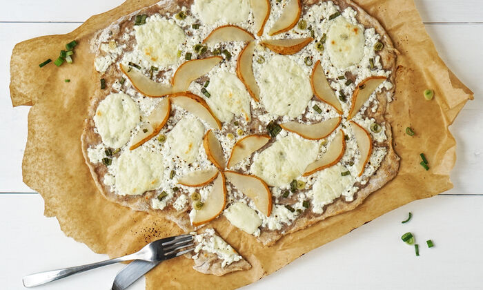 Ricetta della Protinella Tarte flambée di pere e Protinella con crema di formaggio granuloso e cipollotti di GOLDSTEIG su carta da forno