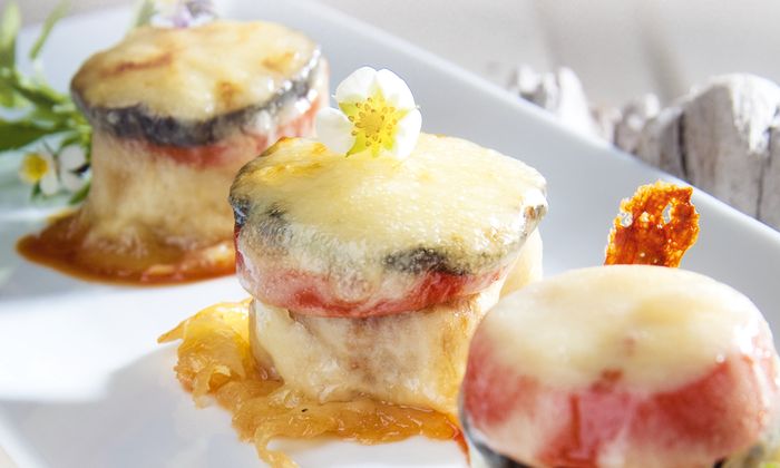 Ricetta della mozzarella Torretta di filetto di maiale con verdure melanzane e pomodori e gratinato con fette di mozzarella GOLDSTEIG su un piatto 