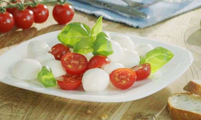 Piatto con pomodori, basilico e Bambini Mozzarella Mini di GOLDSTEIG a pasta filata
