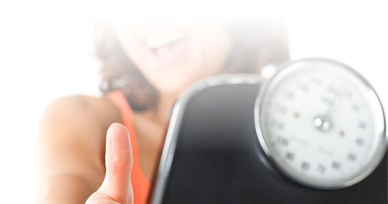 Una donna mostra un paio di bilance.