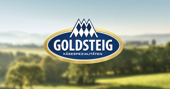 Logo GOLDSTEIG specialità casearie, sullo sfondo paesaggio con boschi e prati