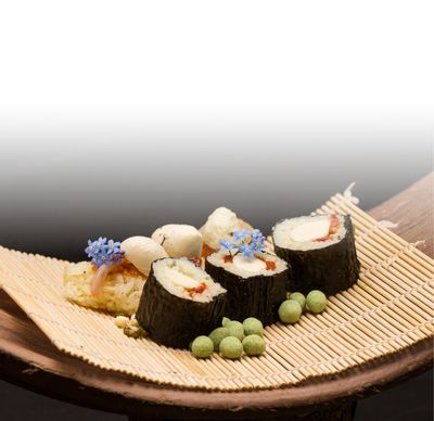Ricetta sushi di mozzarella con Bambini Mozzarella Mini di GOLDSTEIG servita con noci e fiori di wasabi su un tappetino per sushi 
