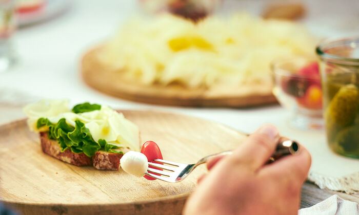 Campagna GOLDSTEIG Spuntino visivo con formaggio su un piatto di legno