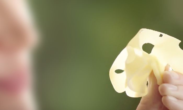 Fetta sottilissima di formaggio GOLDSTEIG tenuta in mano