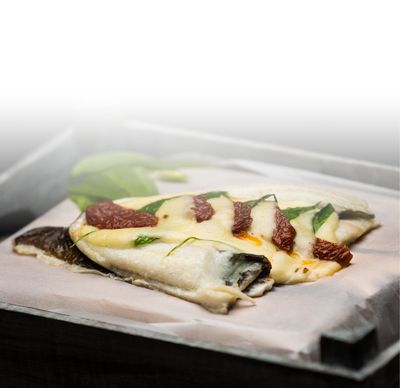 Ricetta della mozzarella Platessa con fette di mozzarella GOLDSTEIG, pomodori secchi e aglio selvatico su un piatto di ferro