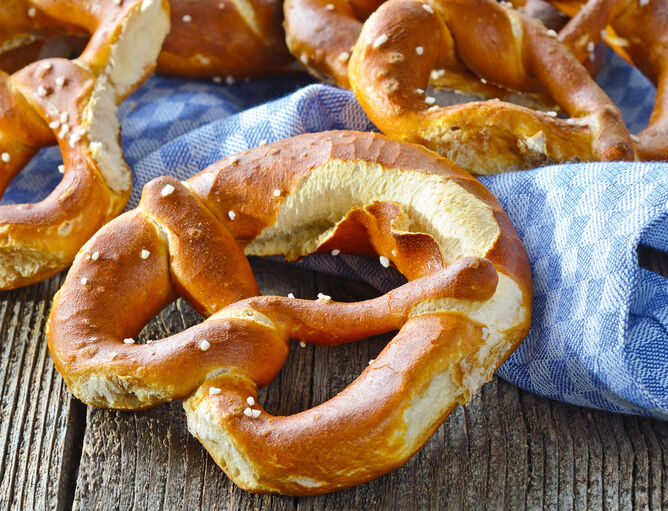Spuntino nella birreria all'aperto: pretzel su un canovaccio blu e bianco e un tavolo di legno 