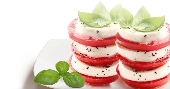 Mozzarella e pomodori disposti in due torri e guarniti con basilico